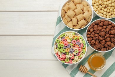 Photo of Different delicious breakfast cereals on white wooden table, flat lay. Space for text