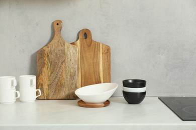 Photo of Wooden cutting boards and dishware on white countertop in kitchen