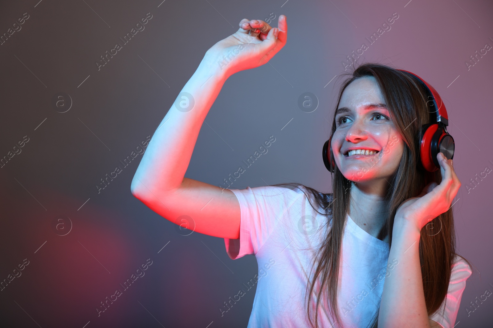 Photo of Portrait of beautiful woman with headphones on color background, space for text