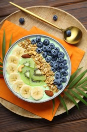 Photo of Tasty smoothie bowl with fresh fruits and oatmeal served on wooden table, top view