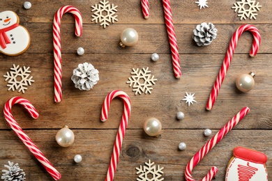 Flat lay composition with candy canes and Christmas decor on wooden background