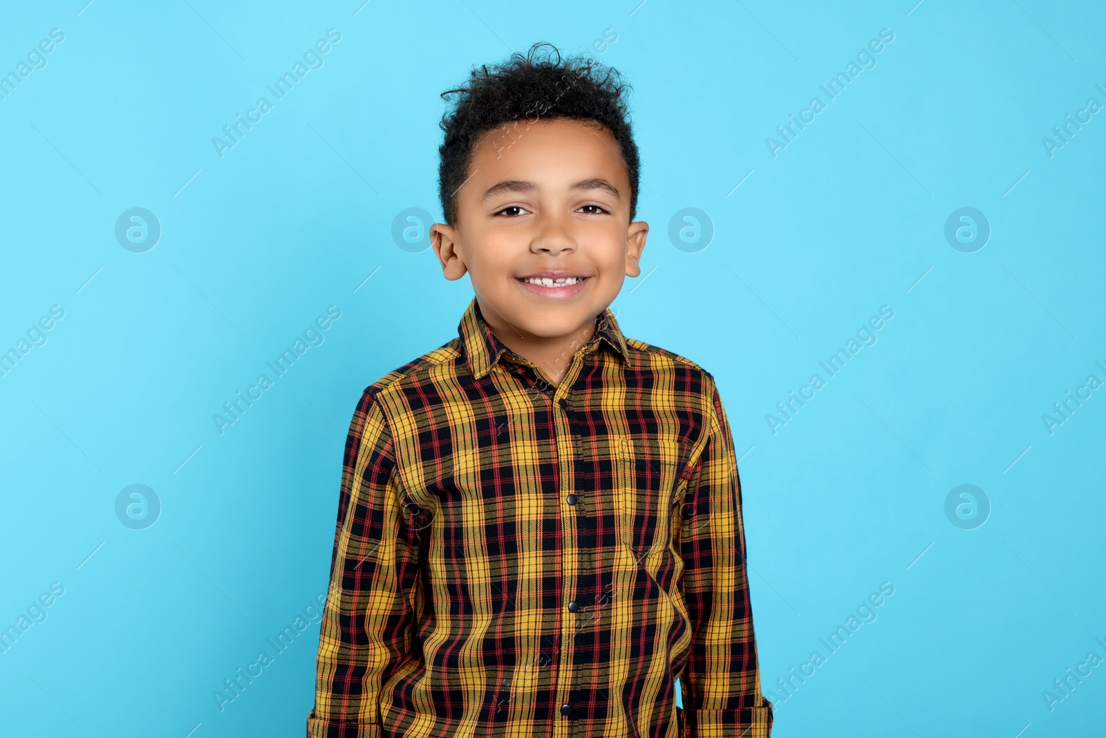 Photo of Portrait of cute African-American boy on turquoise background