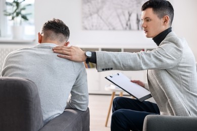 Photo of Professional psychotherapist working with patient in office