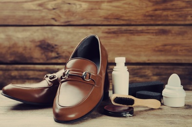 Image of Shoe care accessories and footwear on wooden table