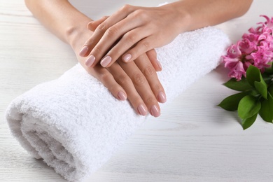 Photo of Closeup view of woman with beautiful hands at table. Spa treatment