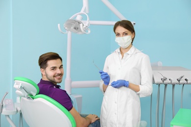 Photo of Professional dentist and patient in modern clinic