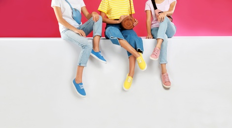 Photo of Women wearing stylish shoes on color background, closeup