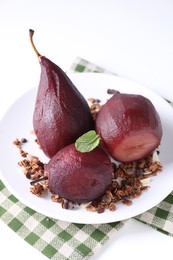 Tasty red wine poached pears with muesli on white table, closeup