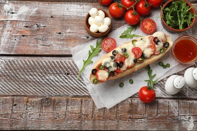 Tasty pizza toast and ingredients on wooden table, top view. Space for text