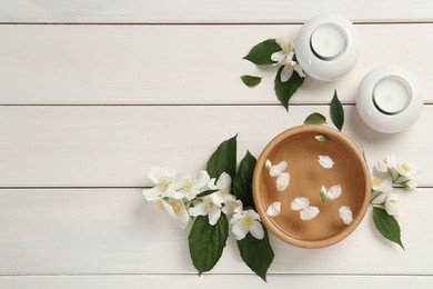 Photo of Flat lay composition with beautiful jasmine flowers and candles on white wooden table, space for text
