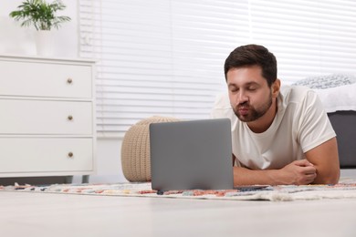 Man sending air kiss during video chat via laptop at home. Long-distance relationship