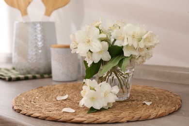 Photo of Beautiful jasmine flowers on wooden table indoors