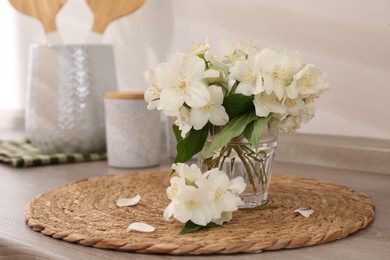 Beautiful jasmine flowers on wooden table indoors