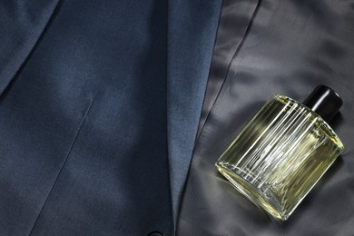 Luxury men's perfume in bottle on grey jacket, above view. Space for text