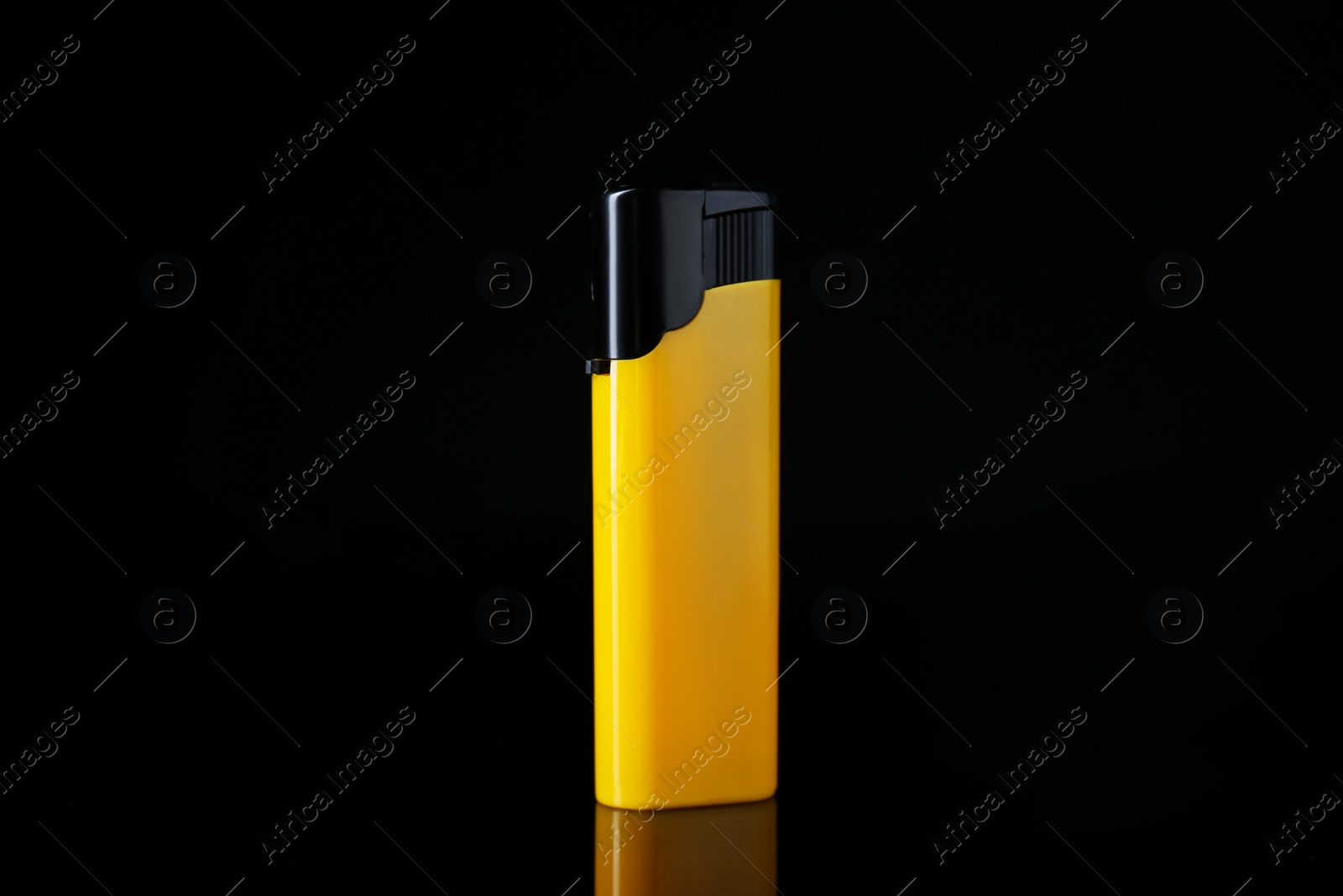 Photo of Yellow plastic cigarette lighter on black background, closeup