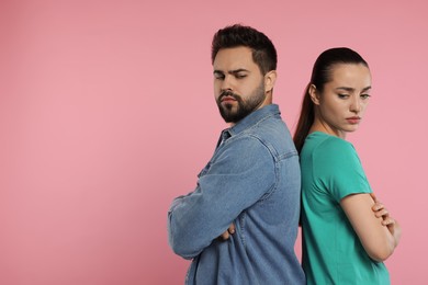 Photo of Resentful couple with crossed arms on pink background, space for text