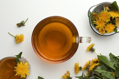 Delicious fresh tea and beautiful dandelion flowers on white background, top view