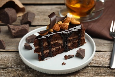 Piece of tasty homemade chocolate cake with nuts on wooden table