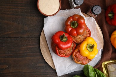 Photo of Delicious stuffed bell peppers served on wooden table, flat lay. Space for text