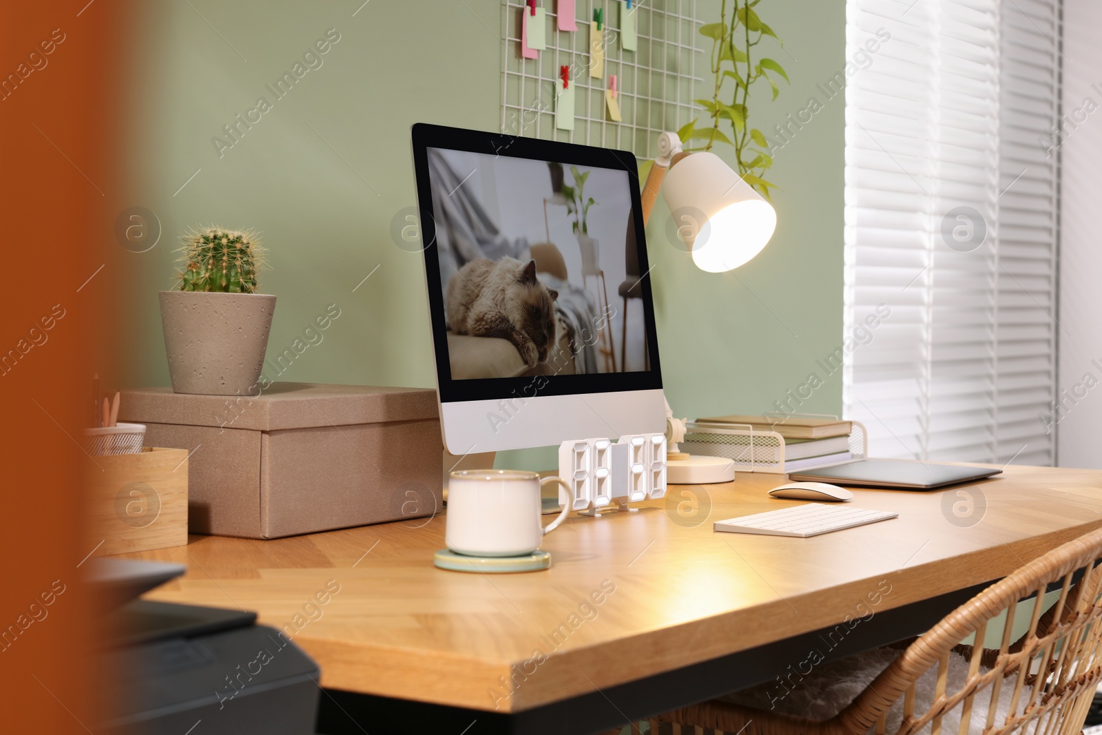 Photo of Stylish workplace with computer, laptop and lamp near olive wall at home