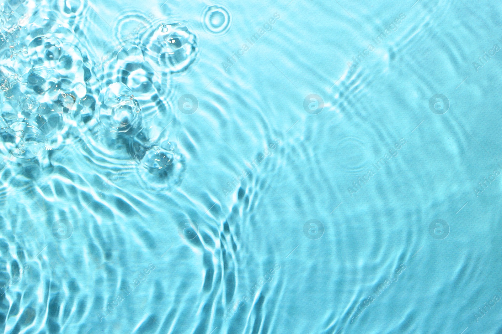 Image of Rippled surface of clear water on light blue background, top view