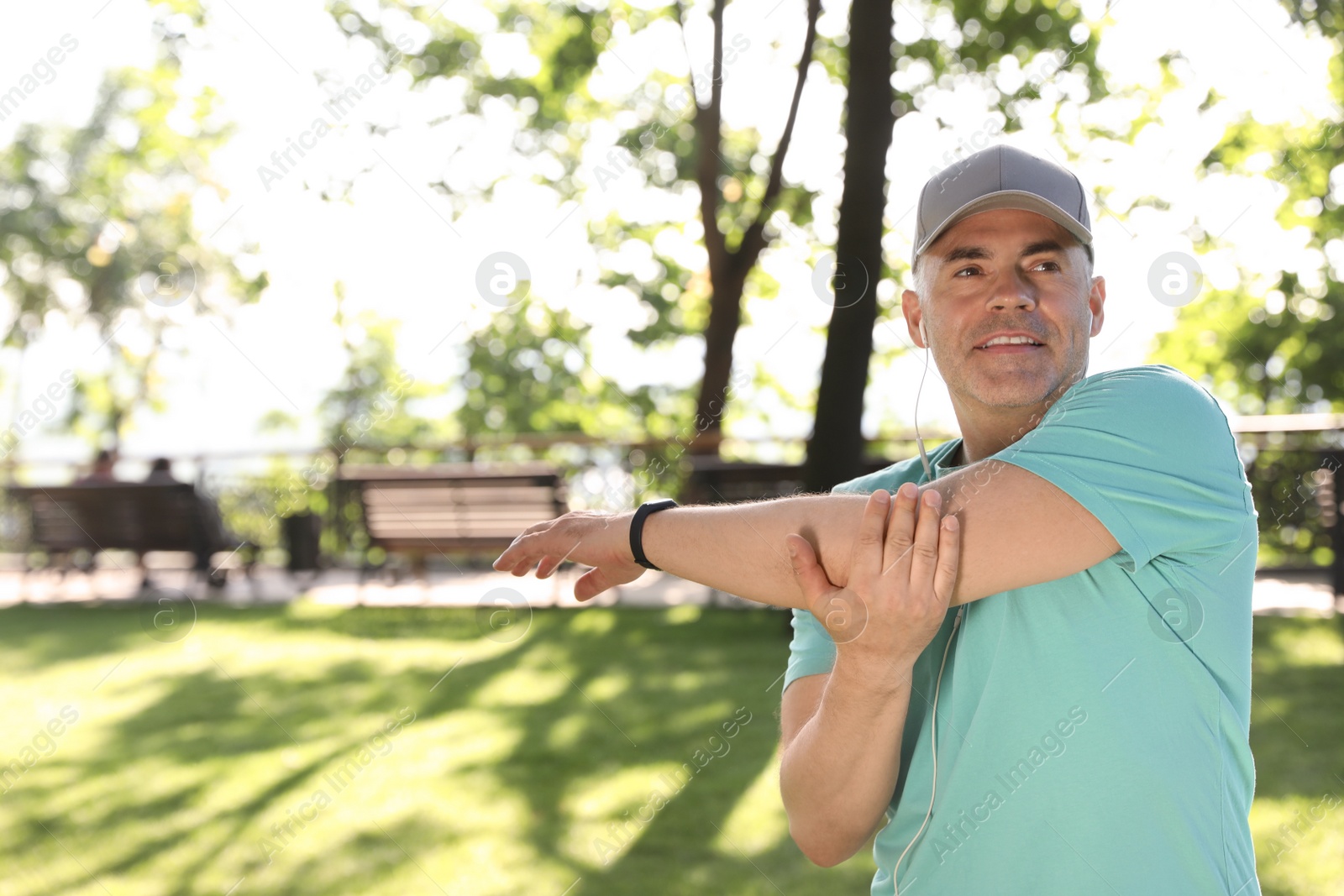 Photo of Handsome mature man doing exercise in park, space for text. Healthy lifestyle