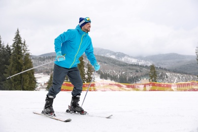 Male skier on slope at resort, space for text. Winter vacation