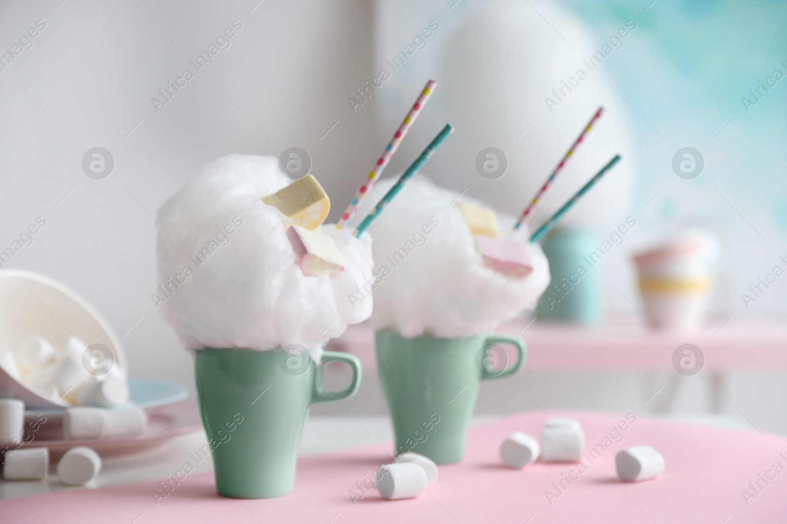 Photo of Cups of tasty cotton candy dessert and marshmallow on table, space for text