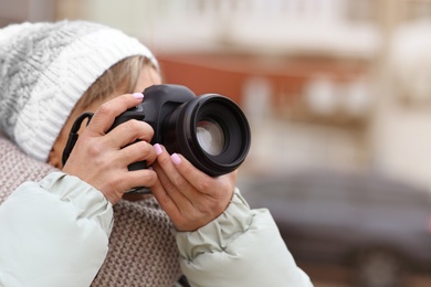 Photographer taking photo with professional camera outdoors