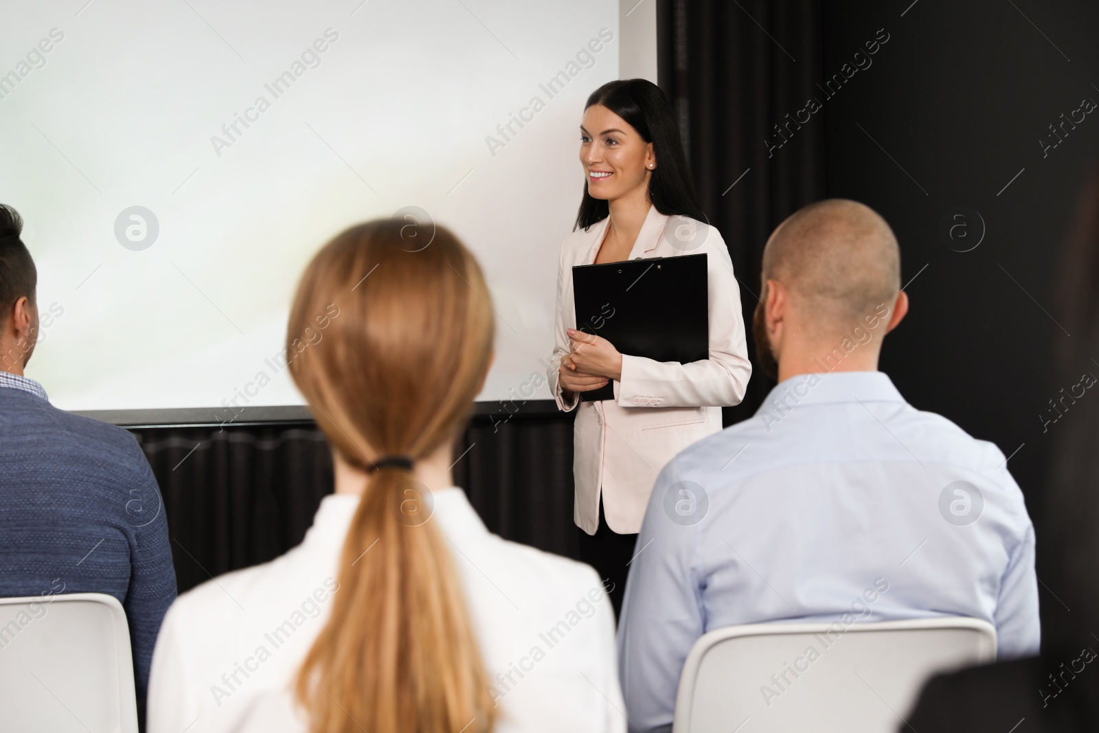 Photo of Business people at seminar in conference room with video projection screen