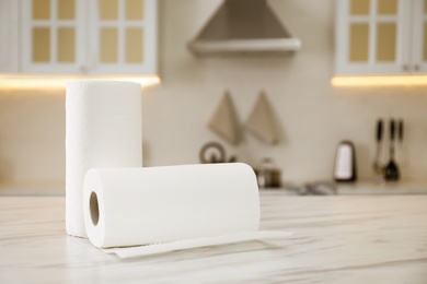Photo of Rolls of paper towels on white table in kitchen