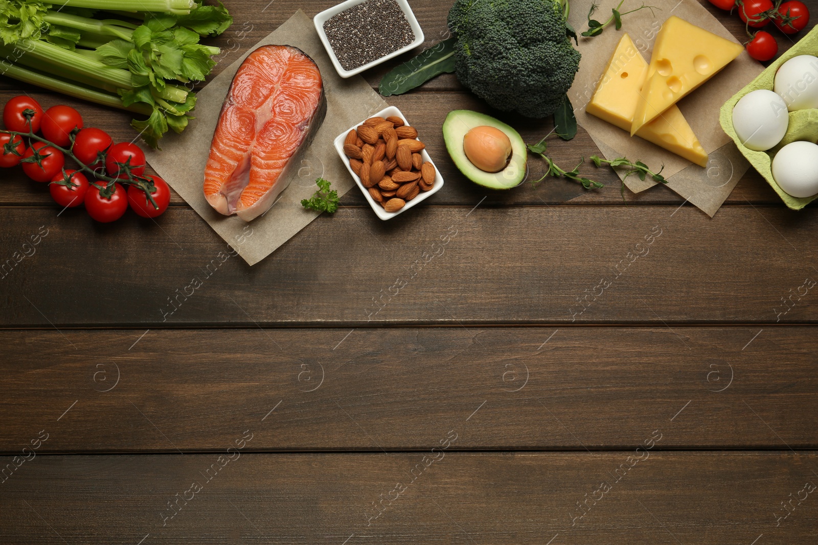 Photo of Flat lay composition with keto diet products on wooden table, space for text