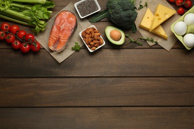 Flat lay composition with keto diet products on wooden table, space for text