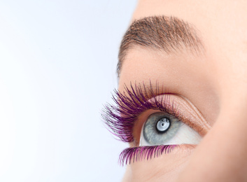 Image of Young woman with beautiful purple eyelashes on light background, closeup. Space for text