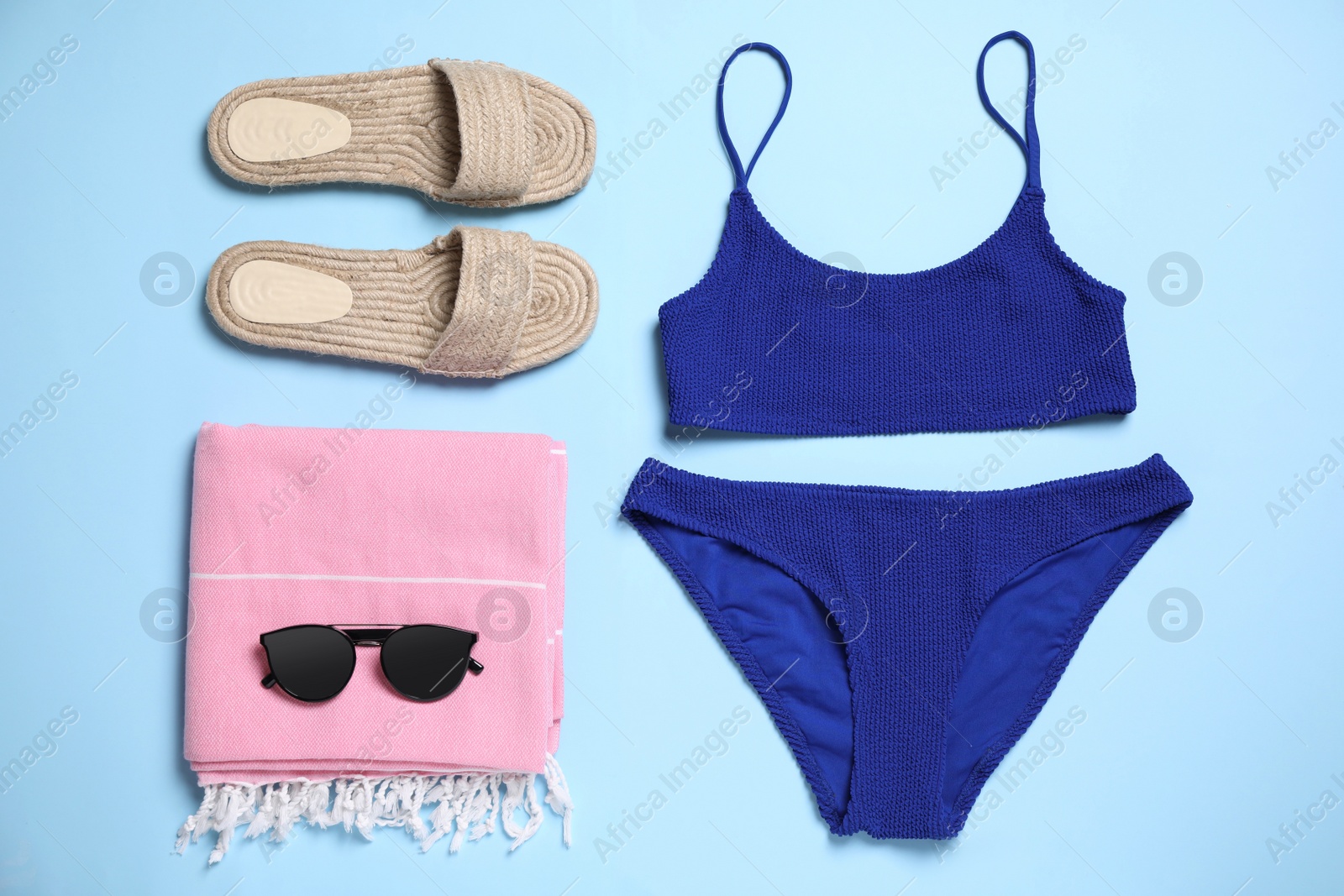 Photo of Flat lay composition with bikini on light blue background