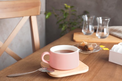 Photo of Cup of hot tea and bags on table. Space for text