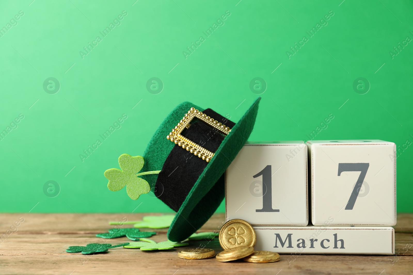 Photo of Composition with block calendar on wooden table. St. Patrick's Day celebration