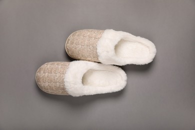 Pair of beautiful soft slippers on grey background, top view