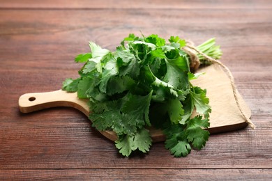 Photo of Fresh green coriander leaves on wooden table