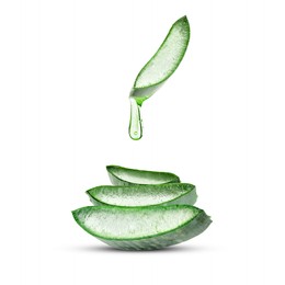 Image of Aloe vera juice dripping from green leaf section on white background