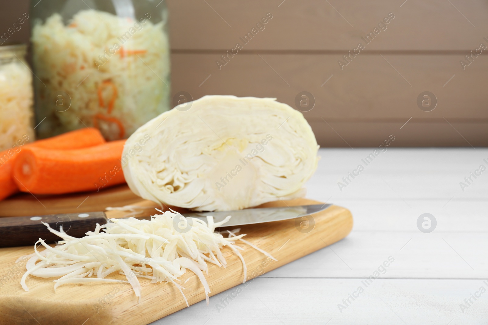 Photo of Cooking delicious sauerkraut soup. Fresh chopped cabbage and ingredients on white wooden table. Space for text