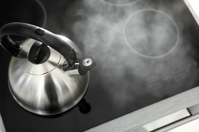 Photo of Modern kettle with whistle on stove, above view. Space for text