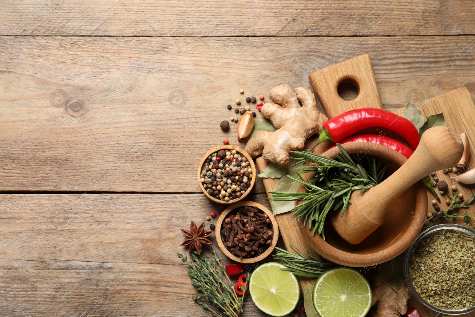Photo of Flat lay composition with different natural spices and herbs on wooden table, space for text