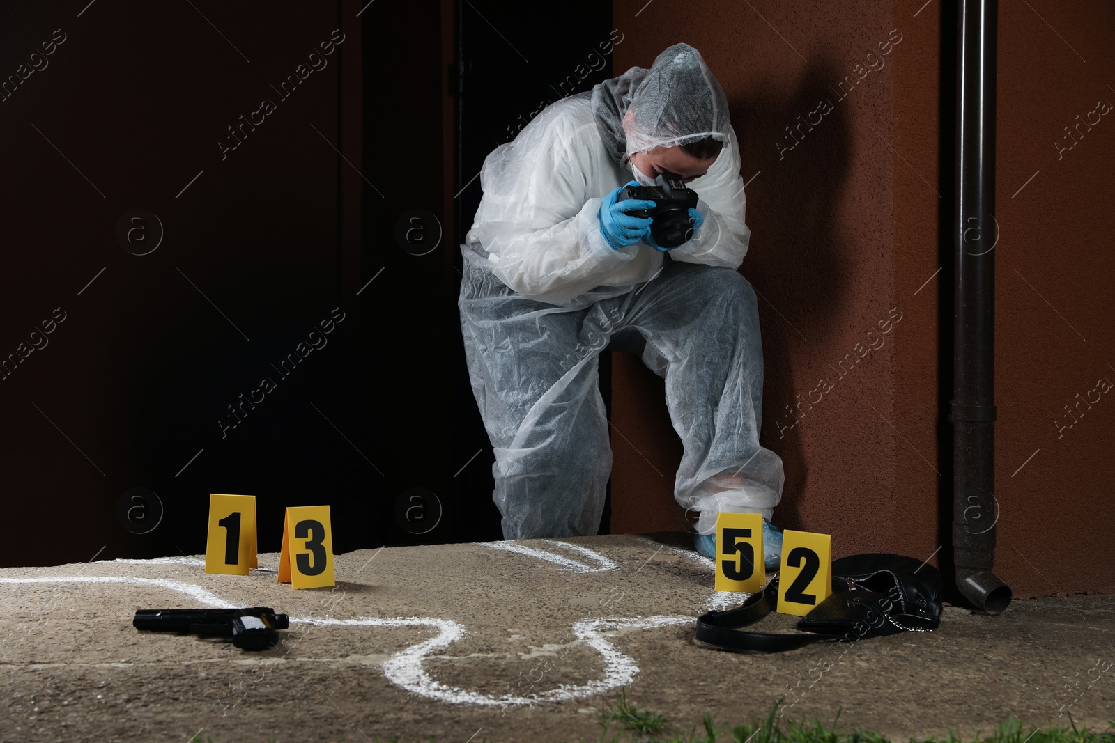 Photo of Criminologist in protective suit working at crime scene outdoors. Space for text