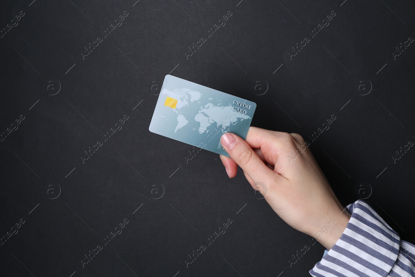 Photo of Woman holding credit card on black background, closeup