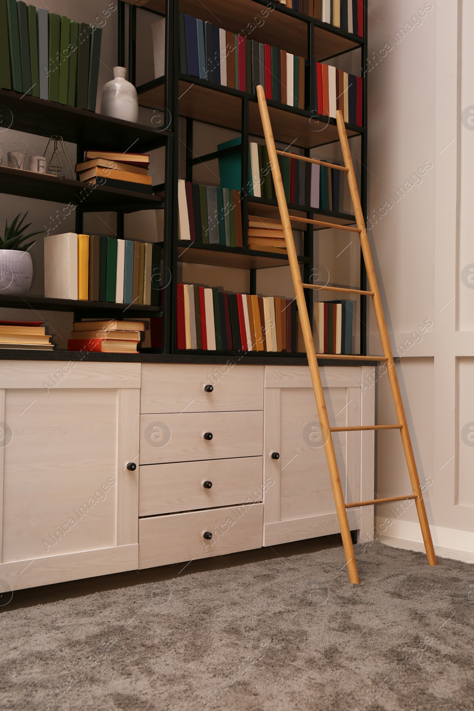 Photo of Home library interior with wooden ladder and collection of books on shelves