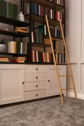 Photo of Home library interior with wooden ladder and collection of books on shelves