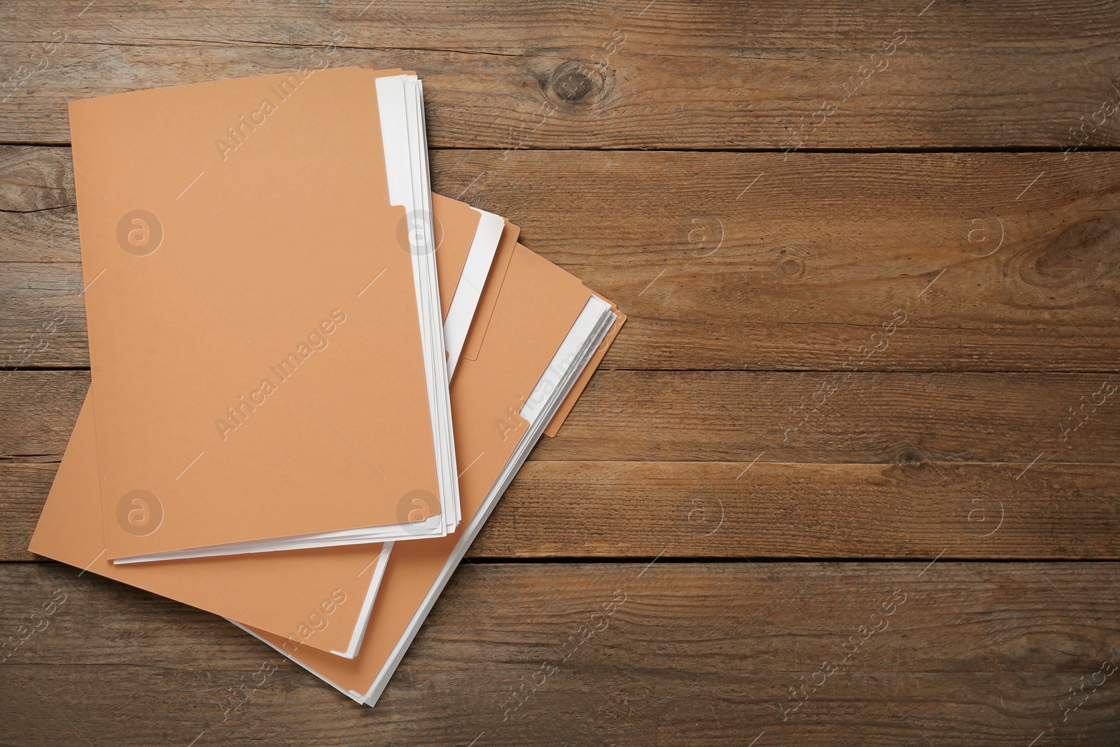 Photo of Yellow files with documents on wooden table, top view. Space for text