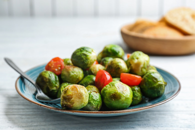 Roasted Brussels sprouts with cherry tomatoes on white wooden table