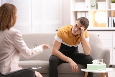 Photo of Psychotherapist working with young man in office